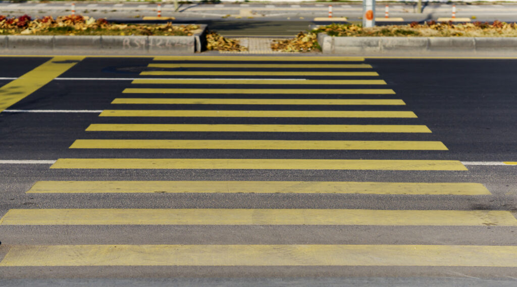 pedestrian road made of yellow lines to cross in traffic