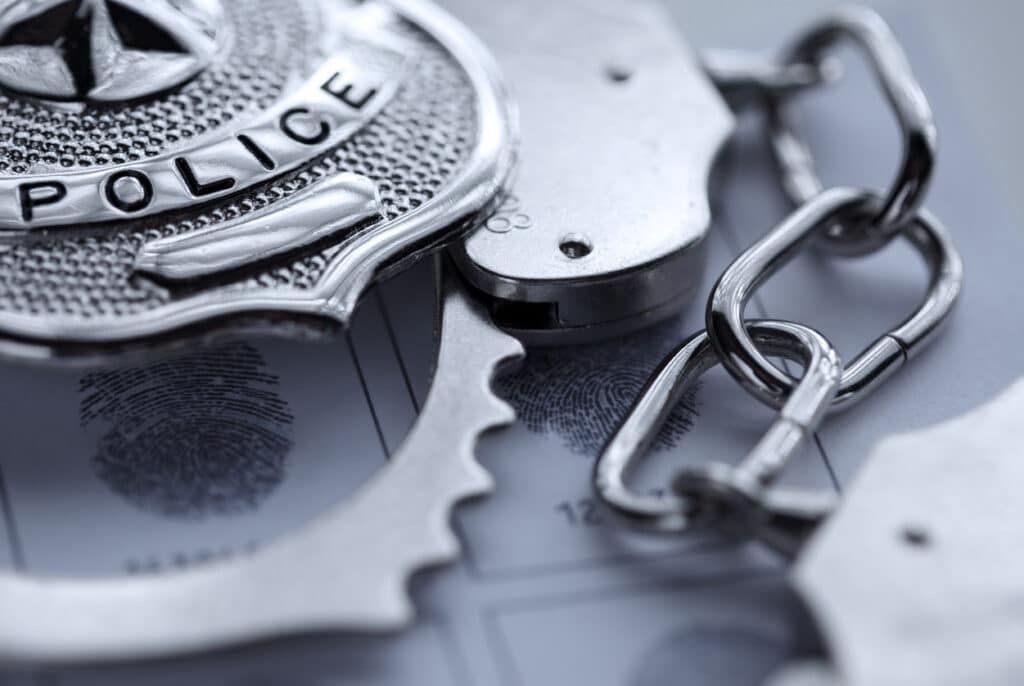 unnamedpolice-badge-resting-on-handcuffs-on-surface-close-up