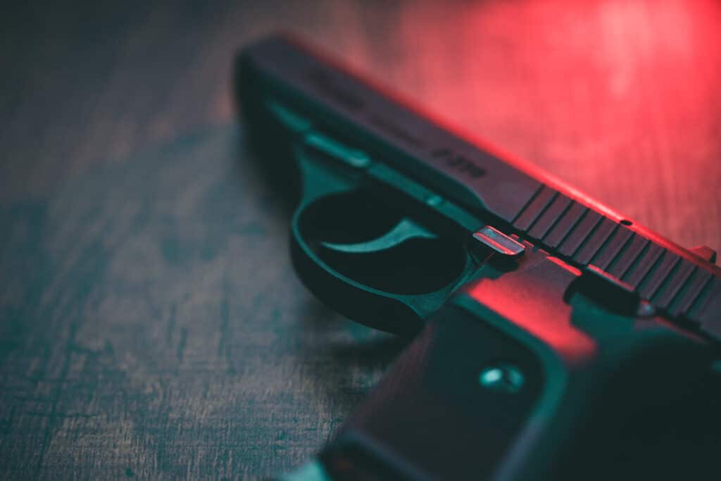 handgun-on-wooden-surface-with-red-light-shining-on-it-from-upper-right-corner