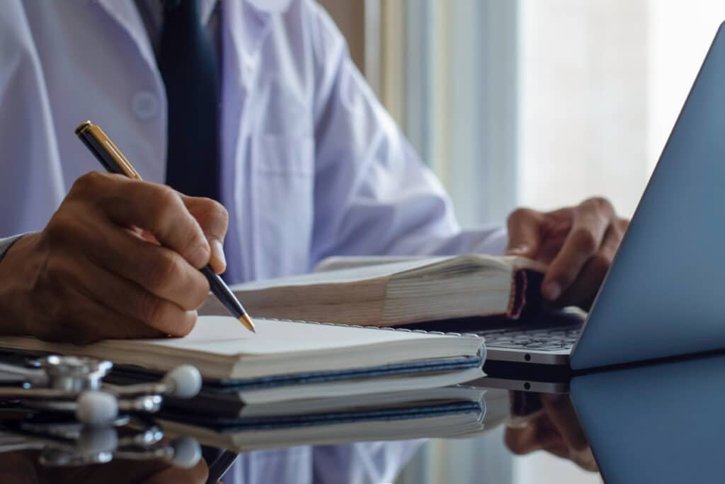 doctor writing information on notebook