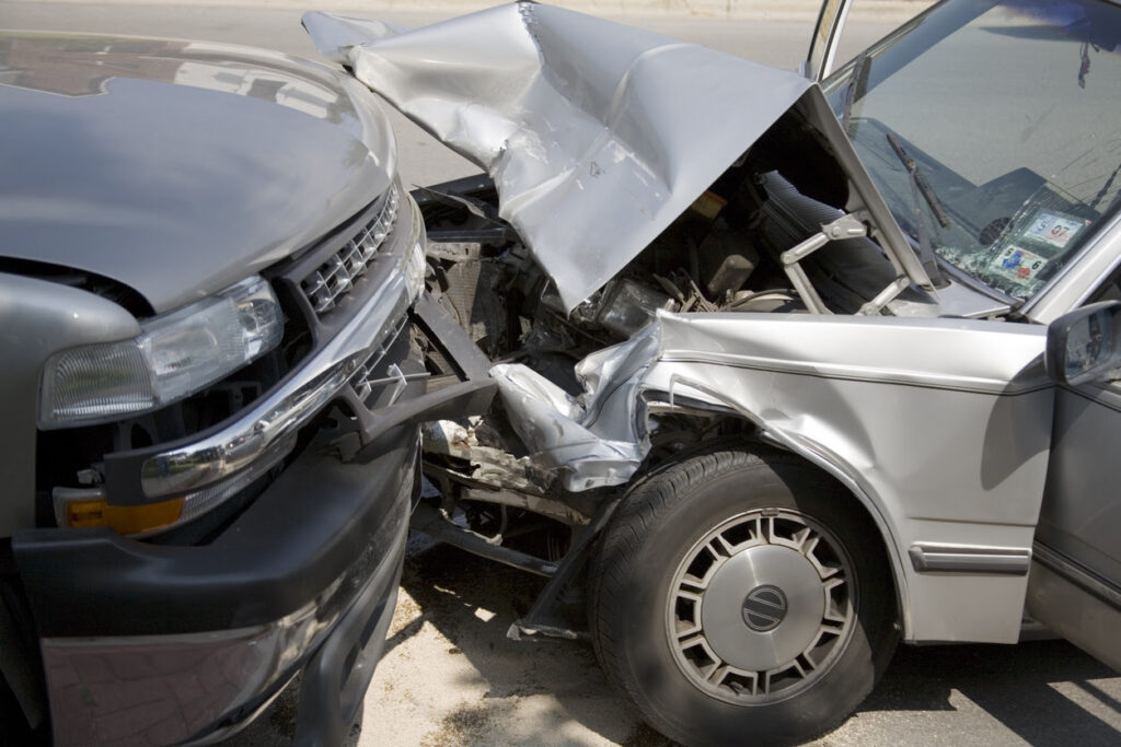 A close-up shot of a head on collision between a car and truck.