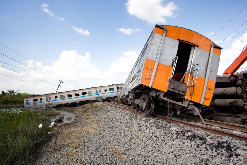An orange train off the train tracks after a derailment.