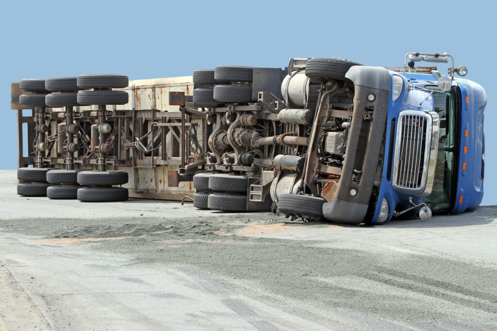 Trucking accident resulting in a big rig rolling over on its side.