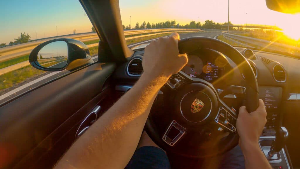 First person shot of cruising down the freeway in a Porsche at sunset.