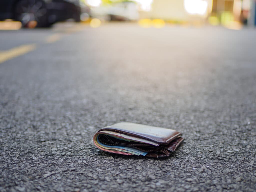 Wallet with money drop on the street after a car crash.