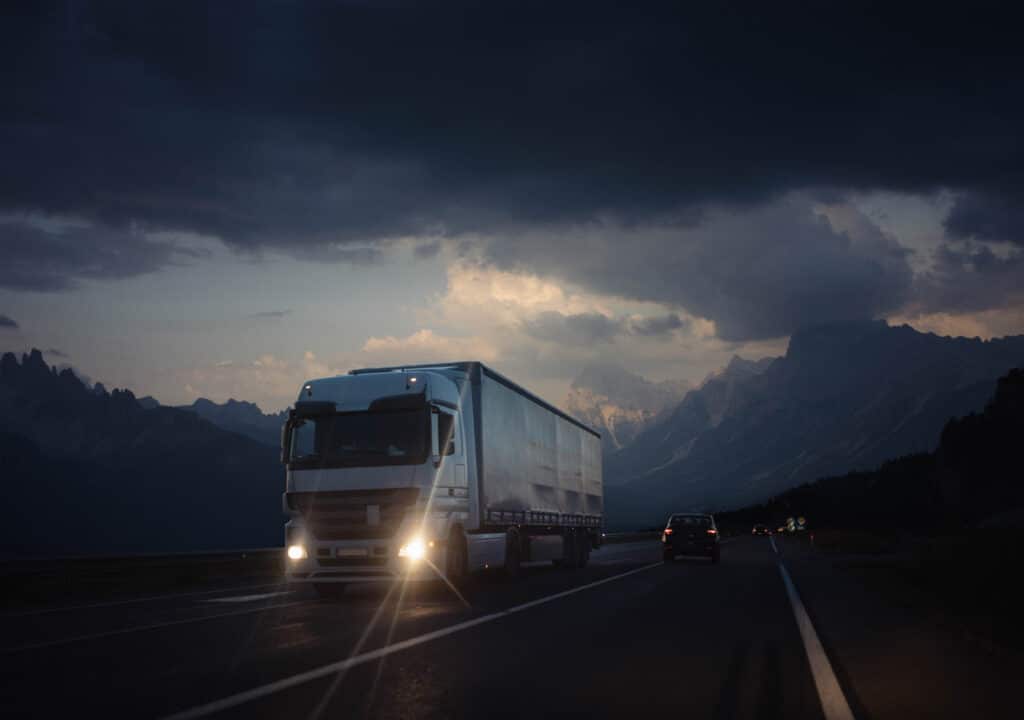 A truck on a highway during the evening.