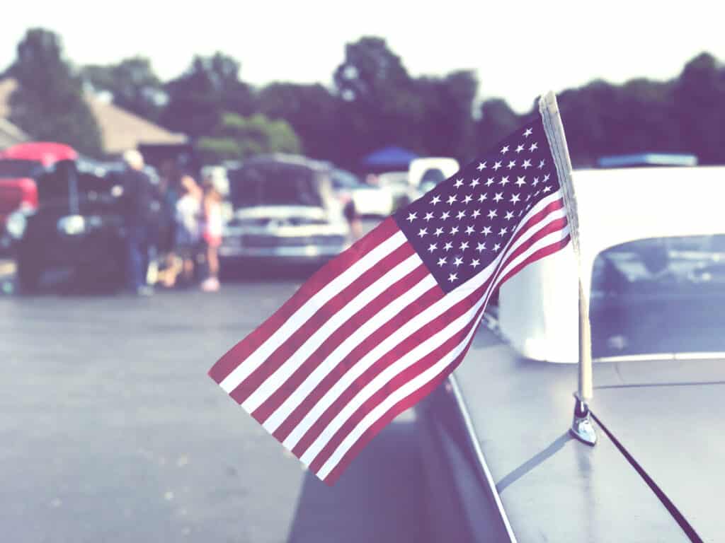 Vintage American flag on old classic car.