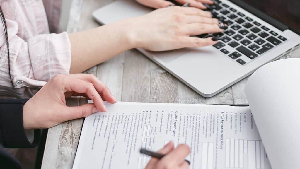 a person filling up an insurance paper